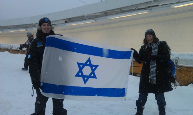 Israeli Bobsleigh and Skeleton Federation CFO Philip Nathan and Chana Anolick hoist the Israeli flag near the end of the track.