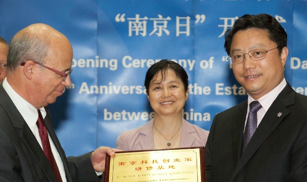 Tel Aviv University President Joseph Klafter shaking hands with Yang Weize, secretary of CPC Nanjing Municipal Committee, at Nanjing Day on the campus, May 21, 2012. Behind them is Chinese Ambassador to Israel Gao Yanping. Photo by Assaf Shilo/Israel Sun